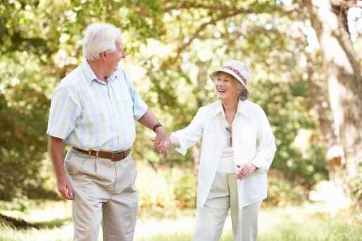 A senior couple go walking outside